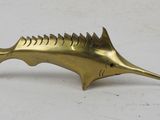 brass fish figurine on a white surface