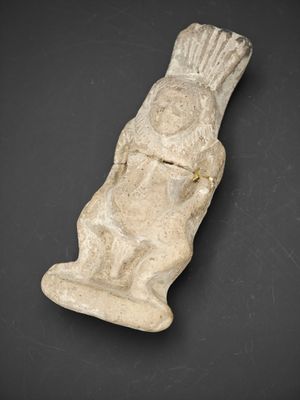 une ancienne figurine en pierre représentant un homme tenant un poisson