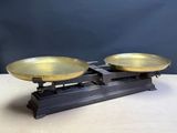 an antique brass scale with two bowls on top of it