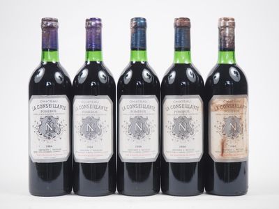 quatre bouteilles de vin sont alignées sur une surface blanche