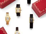 un assortiment de montres et une boîte rouge posée sur un fond blanc