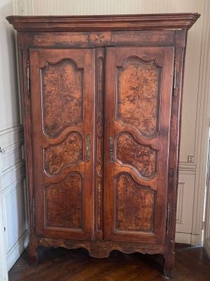 a wooden armoire in the corner of a room