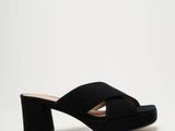 une photo d'une paire de Muler en daim noir avec une bride croisée