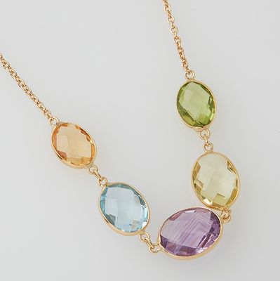a close up of a necklace with three different colored stones