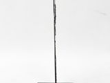 a sculpture of a stick on a black base with a red inscription