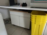 a yellow trash can next to a microwave on the counter