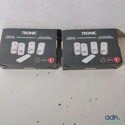 deux boîtes de télécommandes posées sur une table blanche