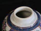 a white vase with a blue and red design on it