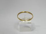 a close up of a gold ring on a clear stand