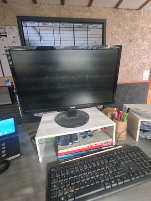 un bureau d'informatique équipé d'un écran, d'un clavier, d'une souris et d'autres accessoires