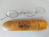 pair of glasses and a wooden case on a table