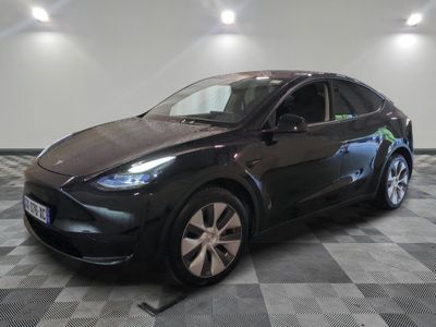 Le SUV Tesla noir est garé dans le garage, sur un sol à damier.
