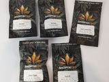 four bags of cannabis tea sit on a white surface