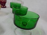 three green glasses sitting on a table next to each other