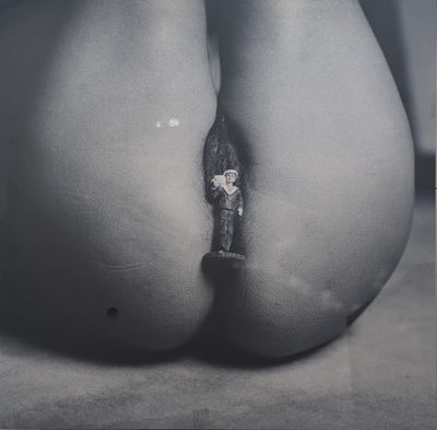photographie en noir et blanc des fesses d'une femme, sur lesquelles est visible une bague en diamant