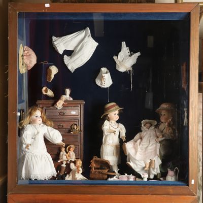 une vitrine contenant des poupées, posée sur une étagère