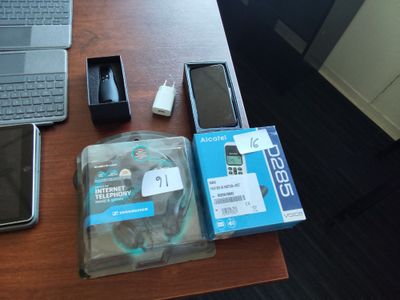 un ordinateur portable, un téléphone portable, un disque dur et un chargeur posés sur un bureau