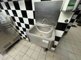 a stainless steel sink in a black and white checkered kitchen