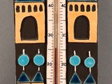 a thermometer with a bird on top of it