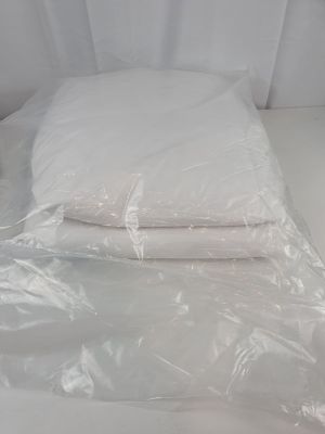 a white bed with two pillows and a pillow on it