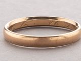 a close up of a gold wedding ring on a table
