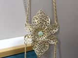 necklace with a flower and a bead hanging from a gold chain
