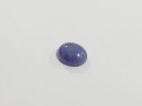 an oval blue sapphire stone sitting on top of a white surface