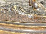 a bronze statue of a man riding a horse on a hill