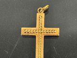 a close up of a gold cross on a black surface