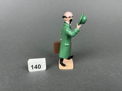 a figurine of a man in a green coat holding a green object