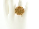 an image of a gold coin ring on a white hand