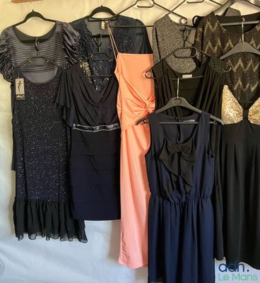 un grand nombre de robes suspendues à une étagère dans une pièce