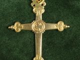 a close up of a gold cross on a green cloth