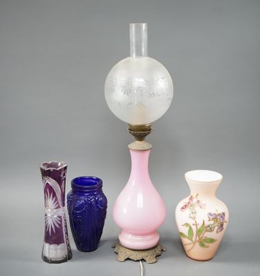 trois vases et une lampe posés sur une table, sur fond gris