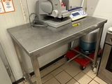 une cuisine équipée d'une table en inox et d'une cuisinière
