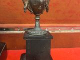 un vase noir posé sur une table rouge