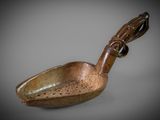 an old wooden spoon with a handle on a gray surface