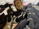 a pile of clothing and shoes on a bed