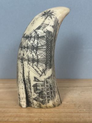 une dent de baleine sur laquelle est dessiné un bateau