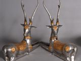 pair of silver and gold deer statues with horns on a gray background