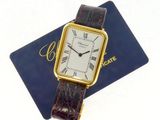 an image of a gold wrist watch sitting on top of a blue card