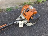 an orange and black blower sitting on the ground next to a wall