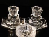 deux bougeoirs en verre transparent posés sur une surface noire