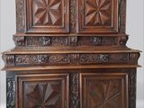 une armoire ancienne en bois, ornée de panneaux sculptés et d'un motif en forme d'étoile