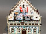 a small doll house with a flag on top of it