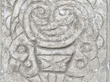 une image représentant une sculpture sur pierre d'un homme coiffé d'un chapeau