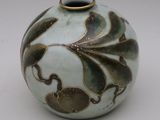 un vase blanc orné d'un motif marron