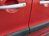 a close up of a red car door with a handle on it