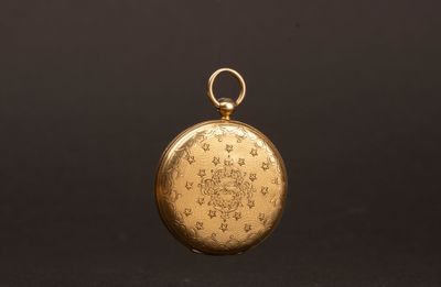 une vieille montre de poche en or avec une chaîne, sur fond noir