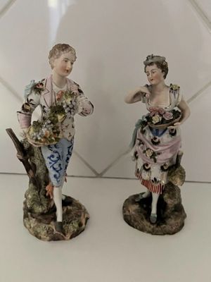 paire de figurines en porcelaine représentant un homme et une femme tenant des fleurs